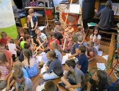 Kinder beim Musizieren im Elztalmuseum umgegeben von Drehorgeln.