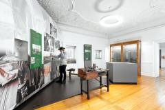 Ein junger Mann bedient in einem Ausstellungsraum eine Hörstation.
